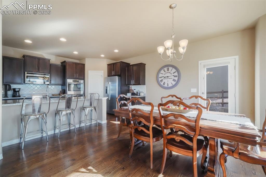 Image 12 of 50: Dining area with hardwood floors, access to back patio and mountain views