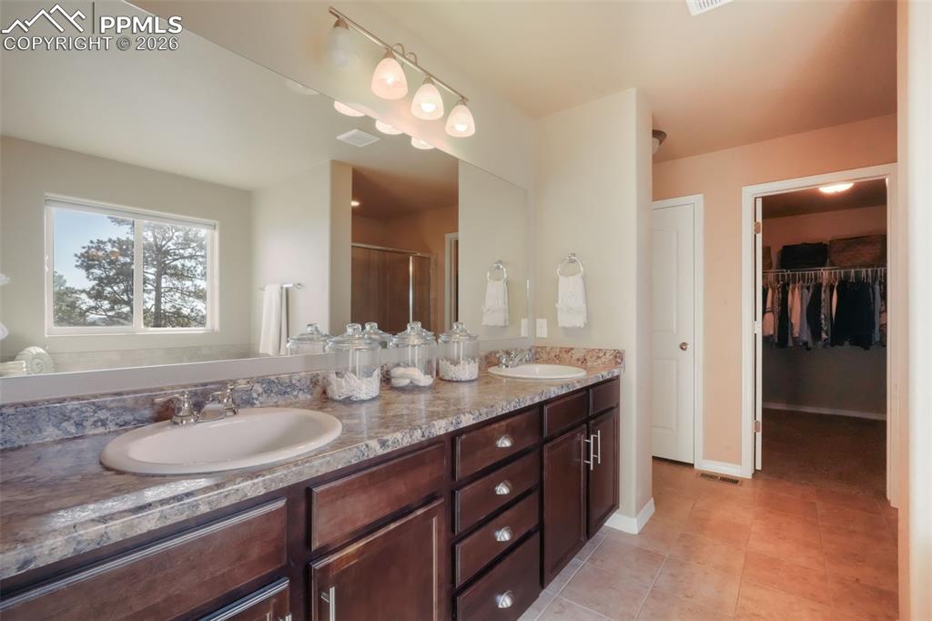 Image 25 of 50: Primary bathroom with dual vanities, soaking tub, large shower, and walk in
