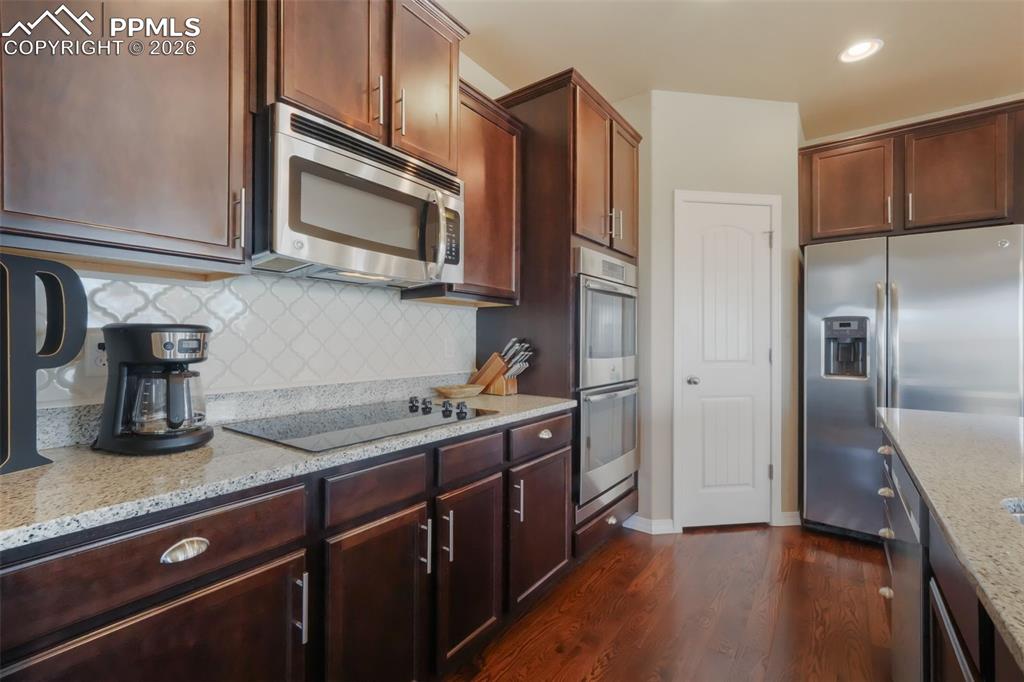 Image 9 of 50: Kitchen with stainless steel appliances, granite counters, double wall oven