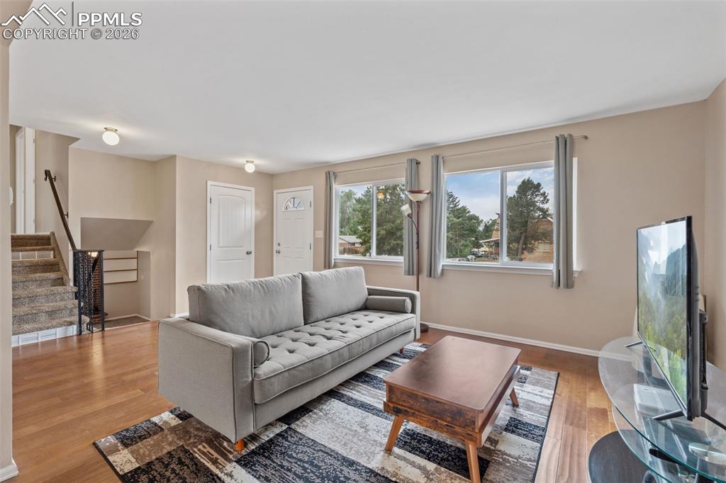 Image 12 of 40: Living room featuring stairs and light wood-style floors