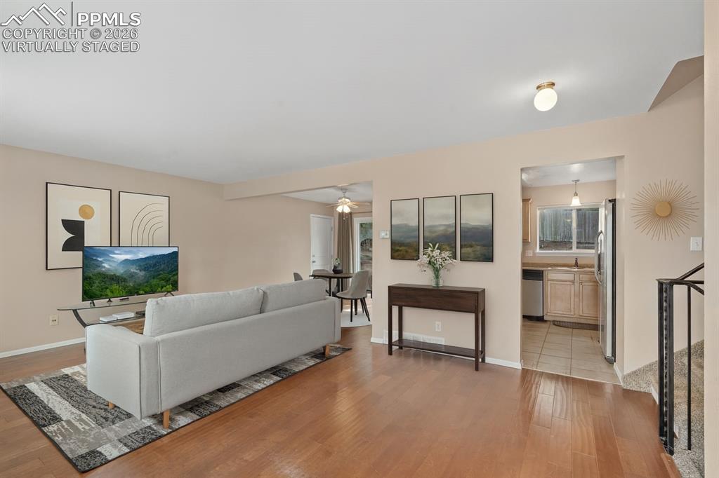Image 13 of 40: Living area featuring light wood-style floors and a ceiling fan. virtually 