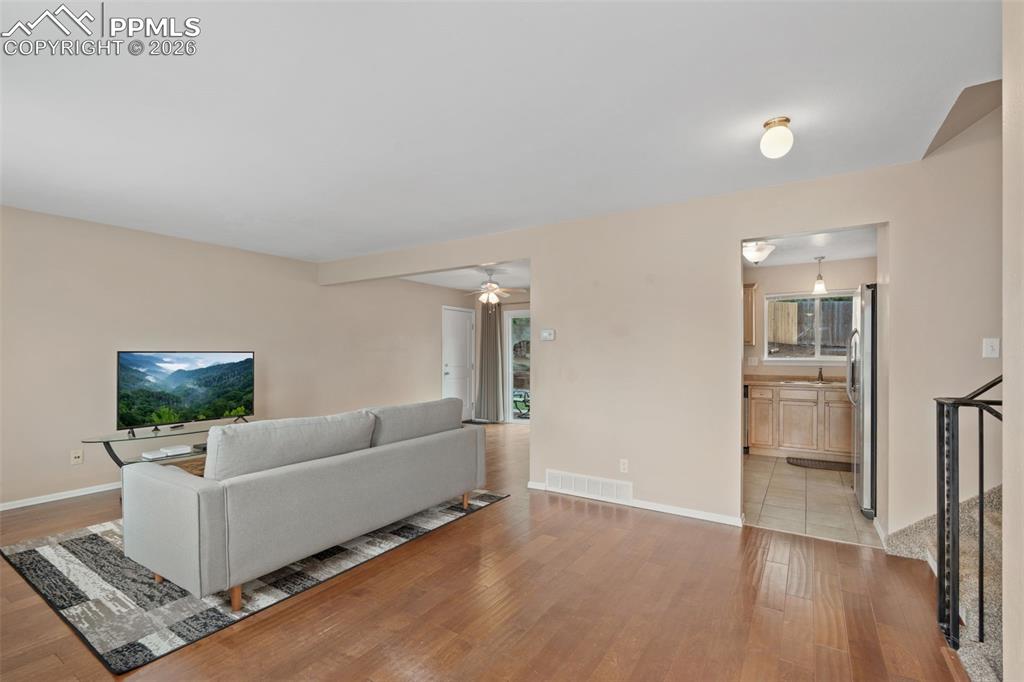 Image 14 of 40: Living room with ceiling fan and light wood-type flooring