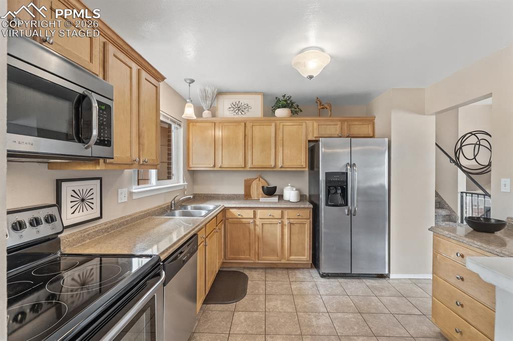 Image 2 of 40: Kitchen featuring stainless steel appliances, light countertops, light tile