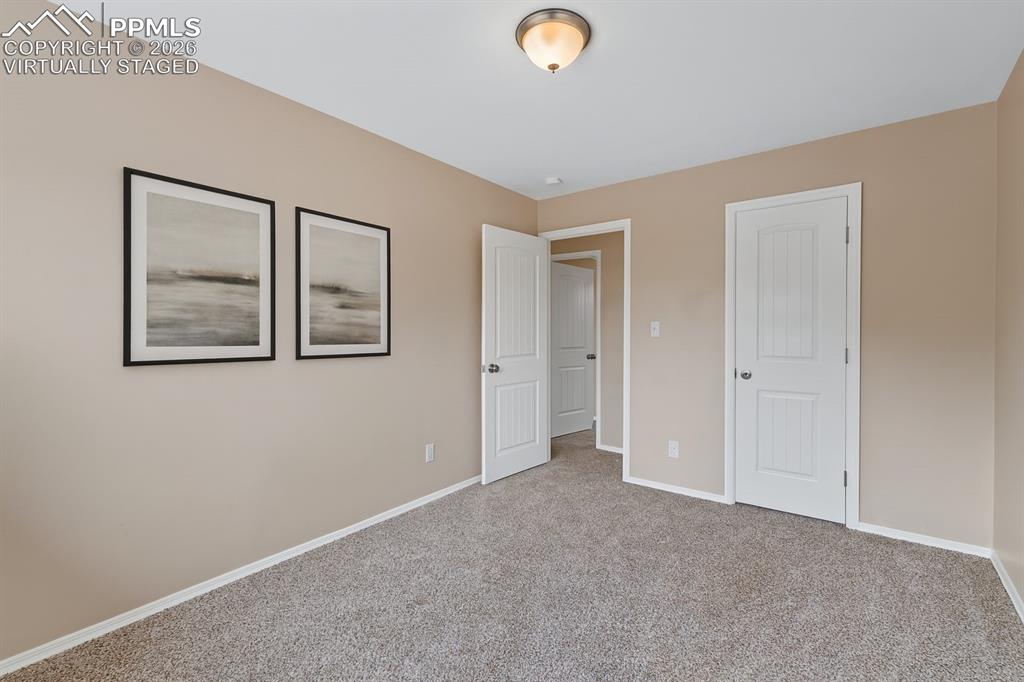 Image 22 of 40: Unfurnished bedroom with baseboards and carpet floors. virtually staged