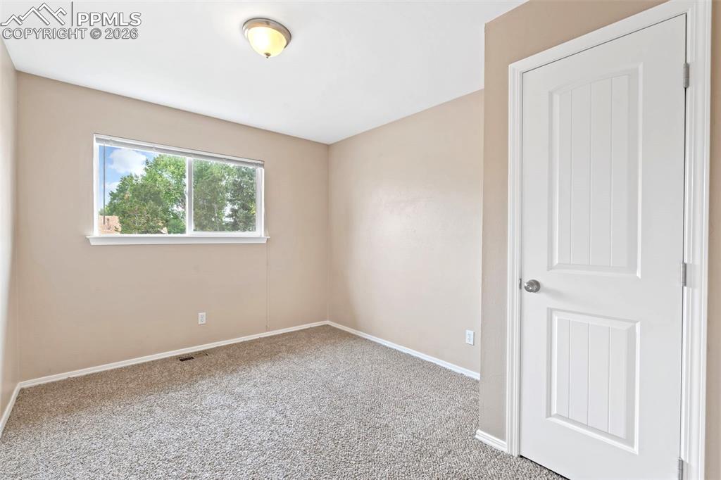 Image 25 of 40: Empty room with light carpet and baseboards