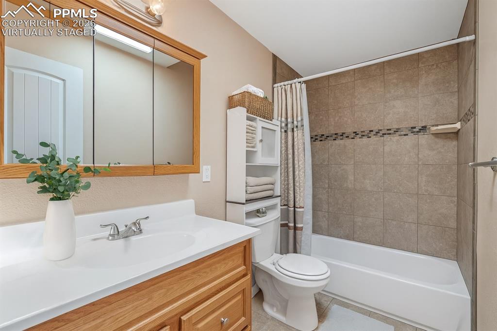 Image 28 of 40: Full bathroom featuring vanity, shower / bathtub combination with curtain, 