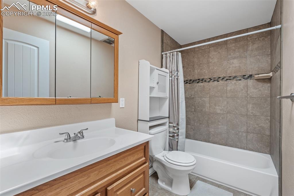 Image 29 of 40: Bathroom featuring vanity, shower / tub combo, and a textured wall