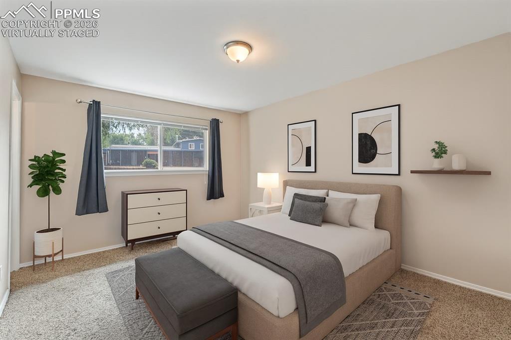Image 30 of 40: Bedroom featuring light carpet and baseboards. virtually staged