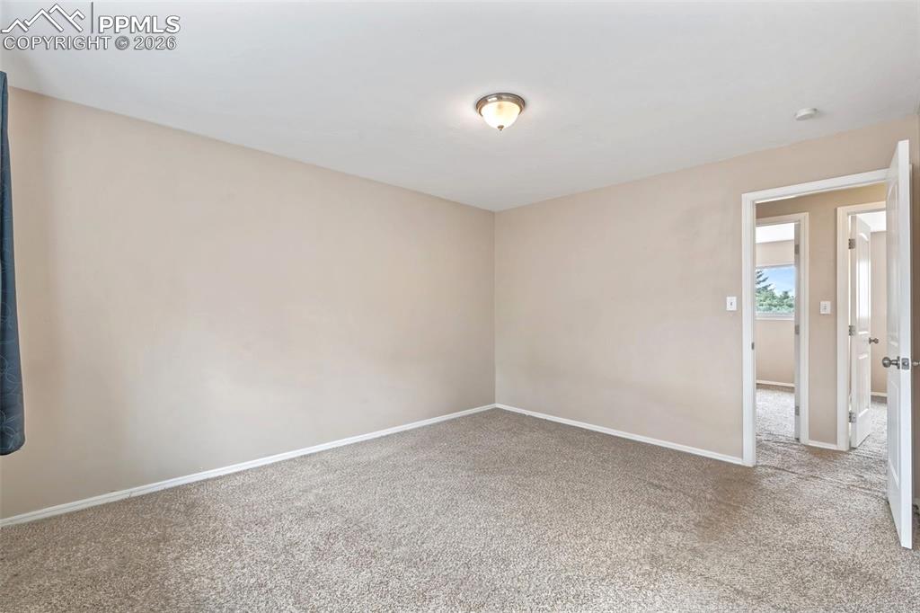 Image 33 of 40: Empty room with carpet floors and baseboards