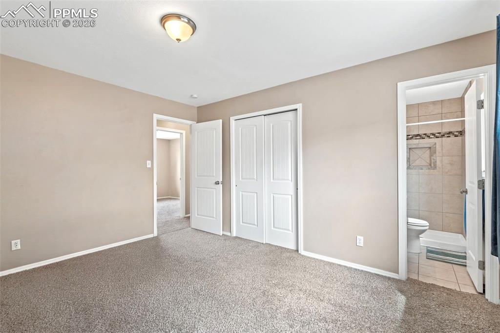 Image 35 of 40: Unfurnished bedroom with light colored carpet, a closet, and connected bath