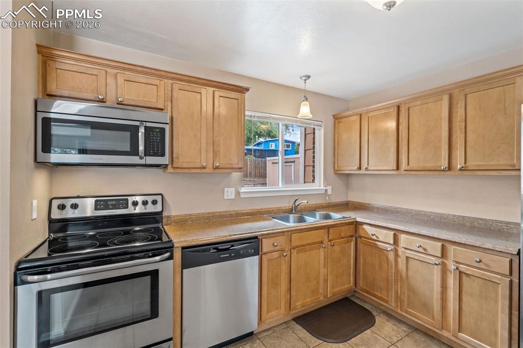 Image 5 of 40: Kitchen featuring stainless steel appliances, pendant lighting, light count