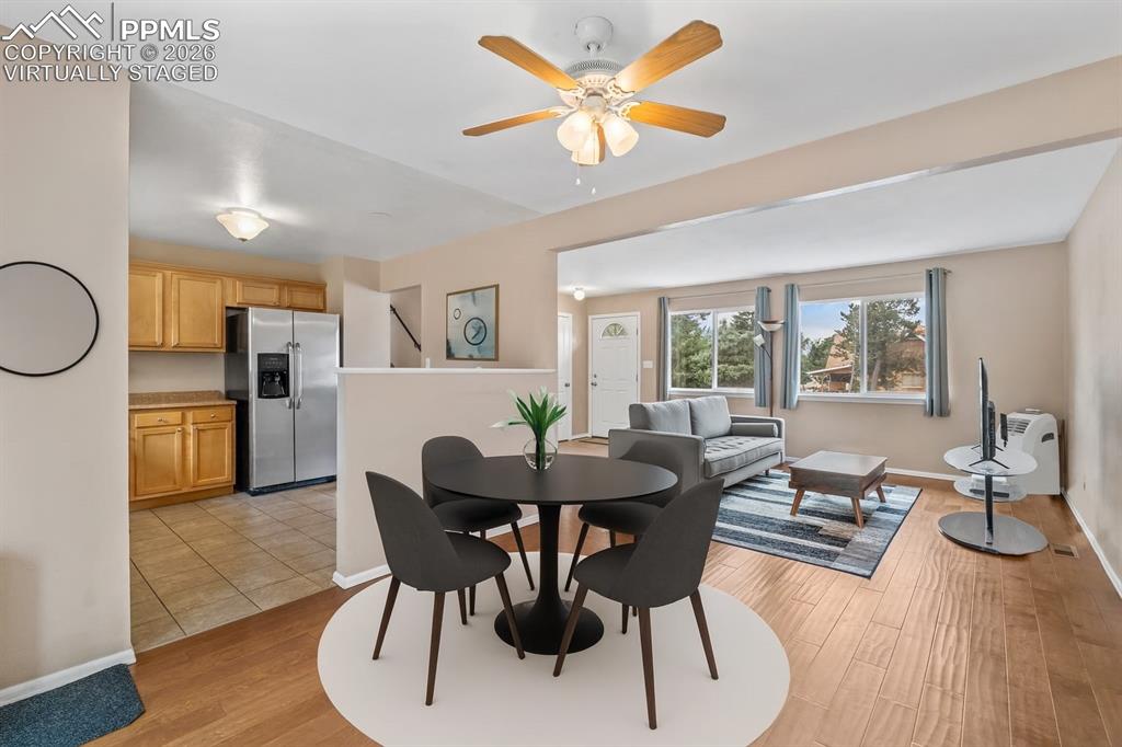 Image 8 of 40: Dining room with light wood-style flooring and a ceiling fan. virtually sta
