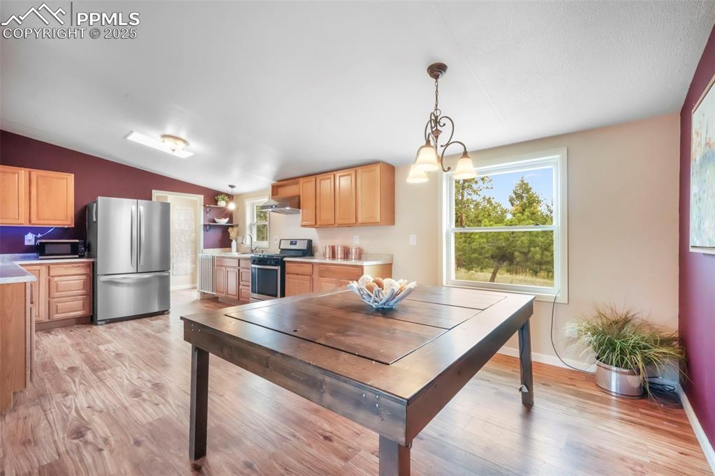 Image 11 of 50: Dining room featuring lofted ceiling, light wood finished floors, and plent