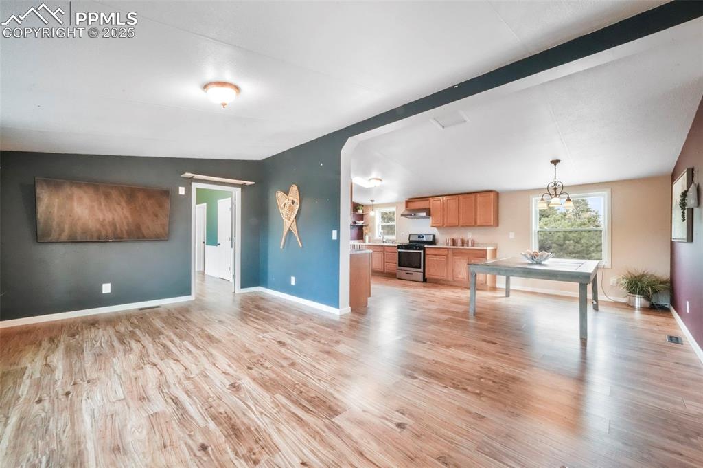 Image 18 of 50: Living room with a barn door, light wood-type flooring, and lofted ceiling
