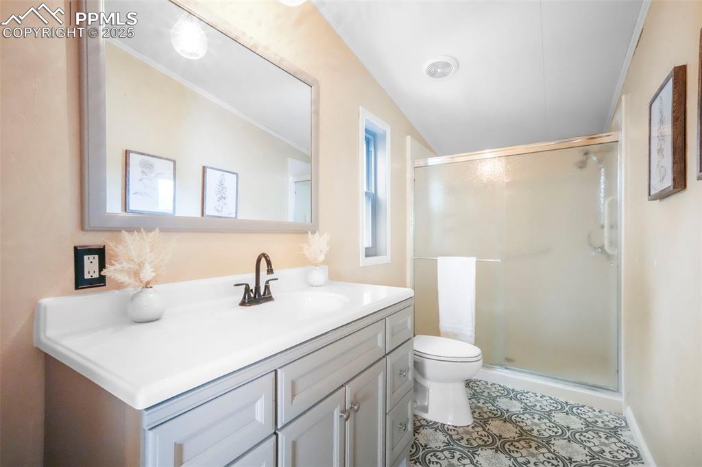 Image 29 of 50: Full bath featuring vanity, a shower stall, ornamental molding, and light t