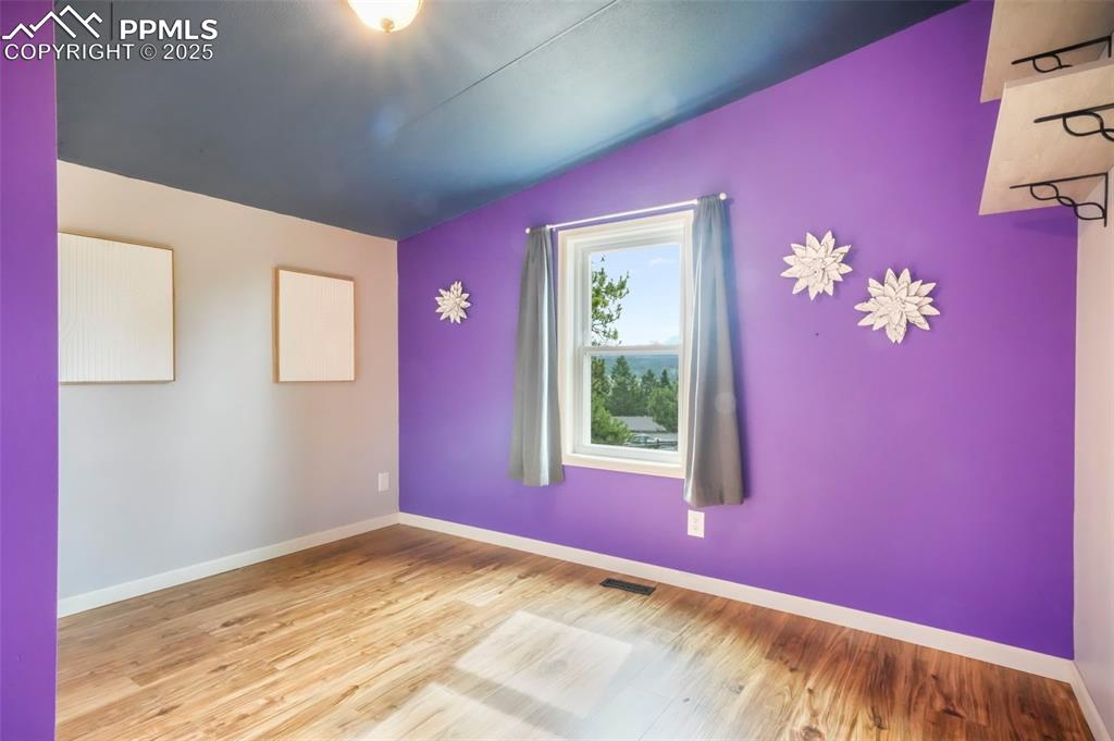 Image 34 of 50: Empty room featuring wood finished floors and lofted ceiling