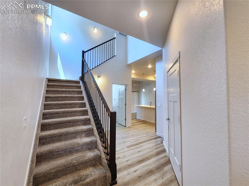 Image 11 of 31: Inviting modern stair railing, high ceiling, and abundant natural light
