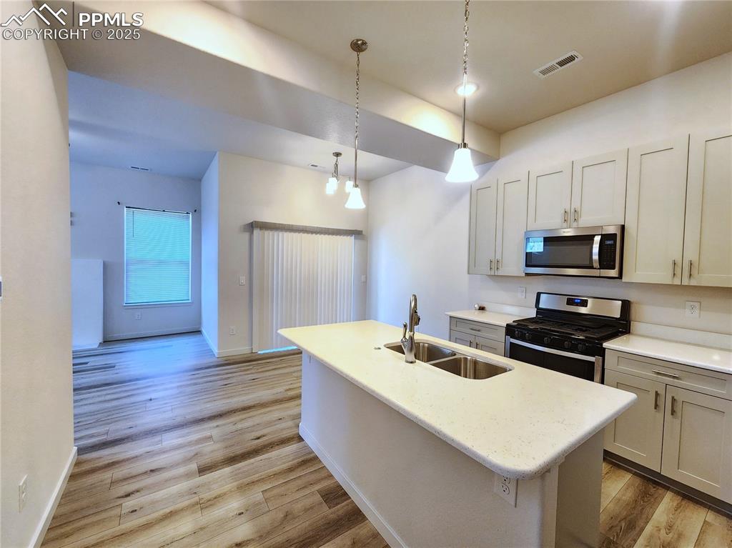 Image 4 of 31: Modern kitchen with center island, stainless steel appliances, and upgraded