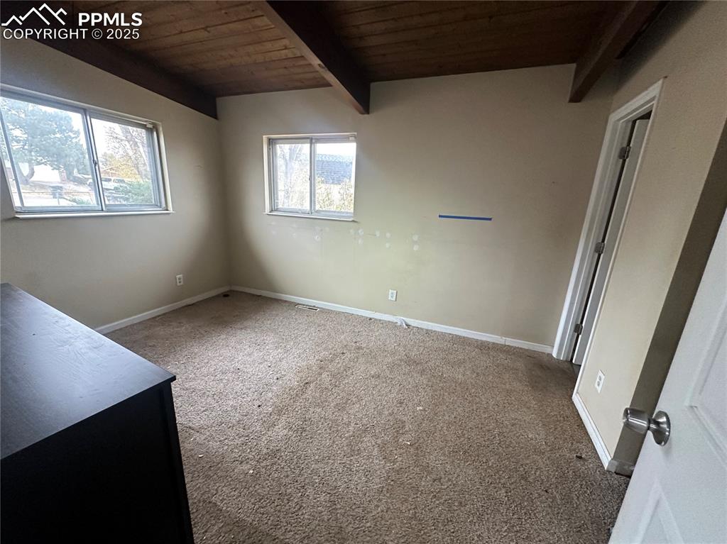 Image 10 of 14: Unfurnished bedroom featuring carpet flooring and a wood ceiling with expos