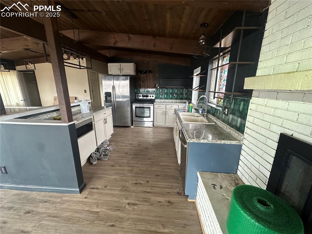Image 4 of 14: Kitchen featuring white cabinetry, open shelves, stainless steel appliances