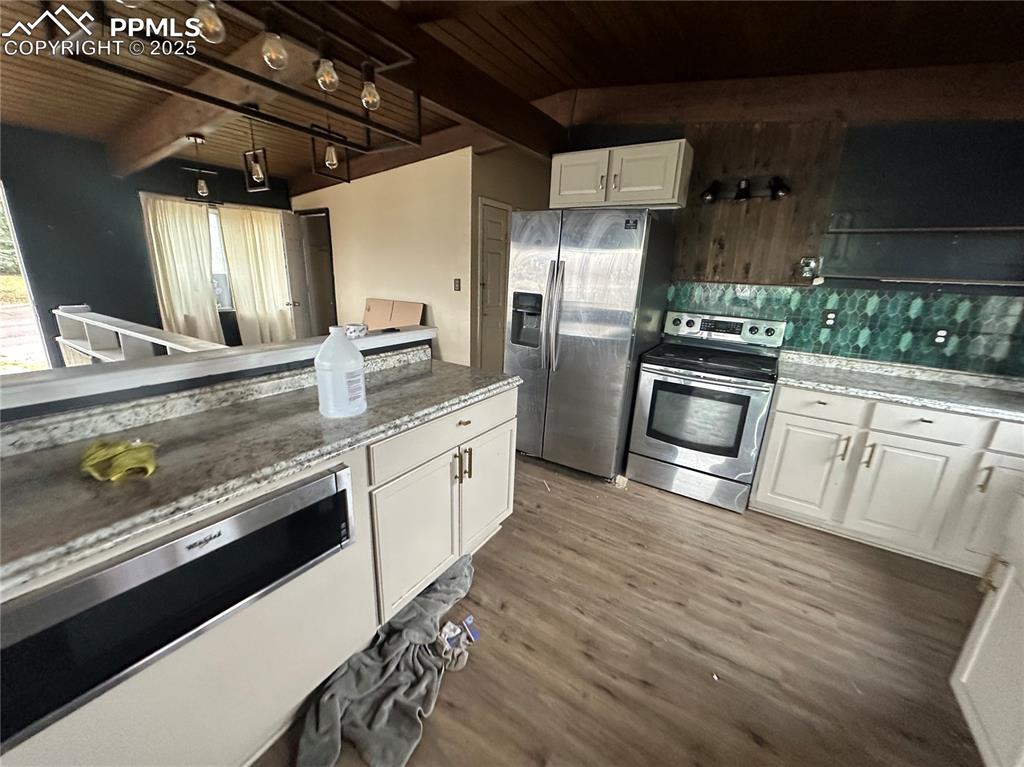 Image 5 of 14: Kitchen with white cabinetry, appliances with stainless steel finishes, dec