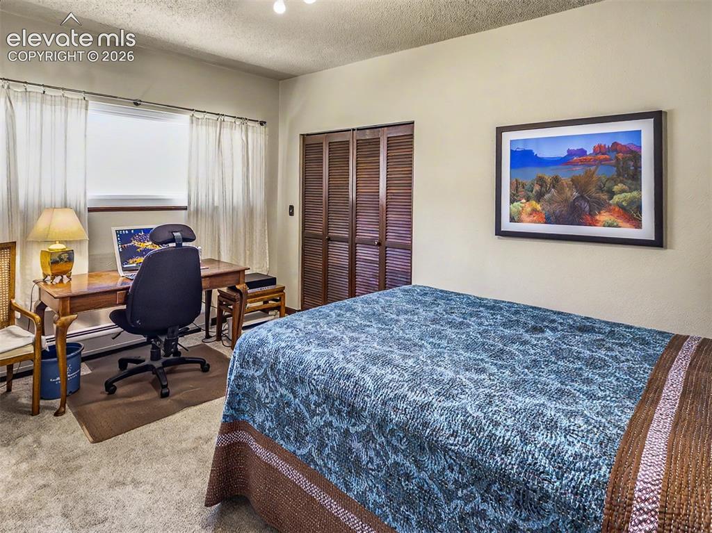 Image 12 of 27: Guest room 2 featuring a window with white curtains, a built-in closet with