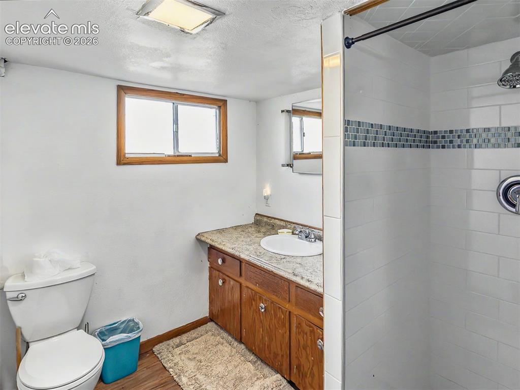 Image 15 of 27: Basement Bathroom featuring a walk-in shower with white subway tile and dec