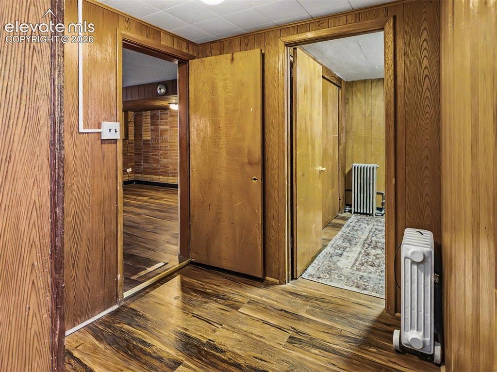 Image 18 of 27: Wood-finish flooring and wood paneling throughout