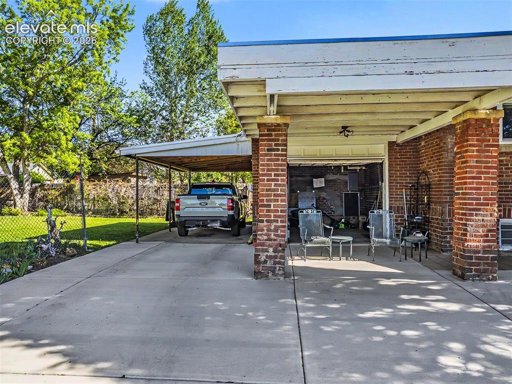 Image 20 of 27: Driveway runs to attached garage and carport