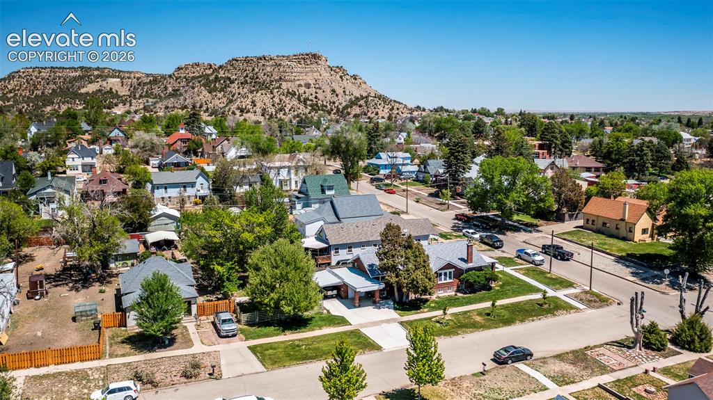 Image 25 of 27: Neighborhood setting featuring mature trees, paved streets, and residential