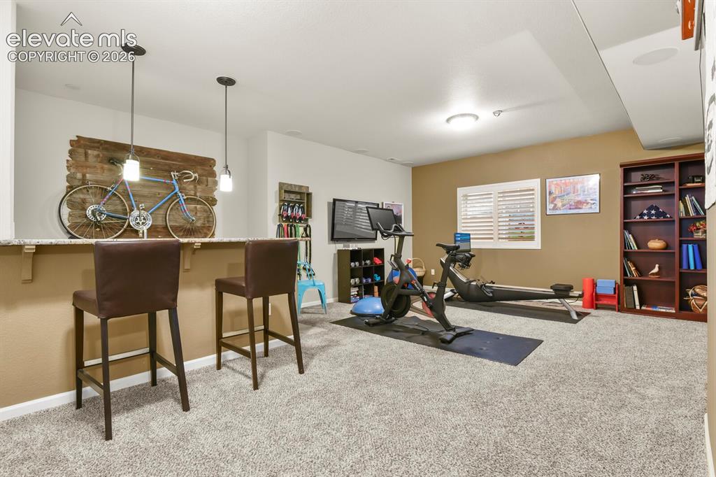 Image 28 of 47: Basement rec room with wet bar and surround sound ready to set up.