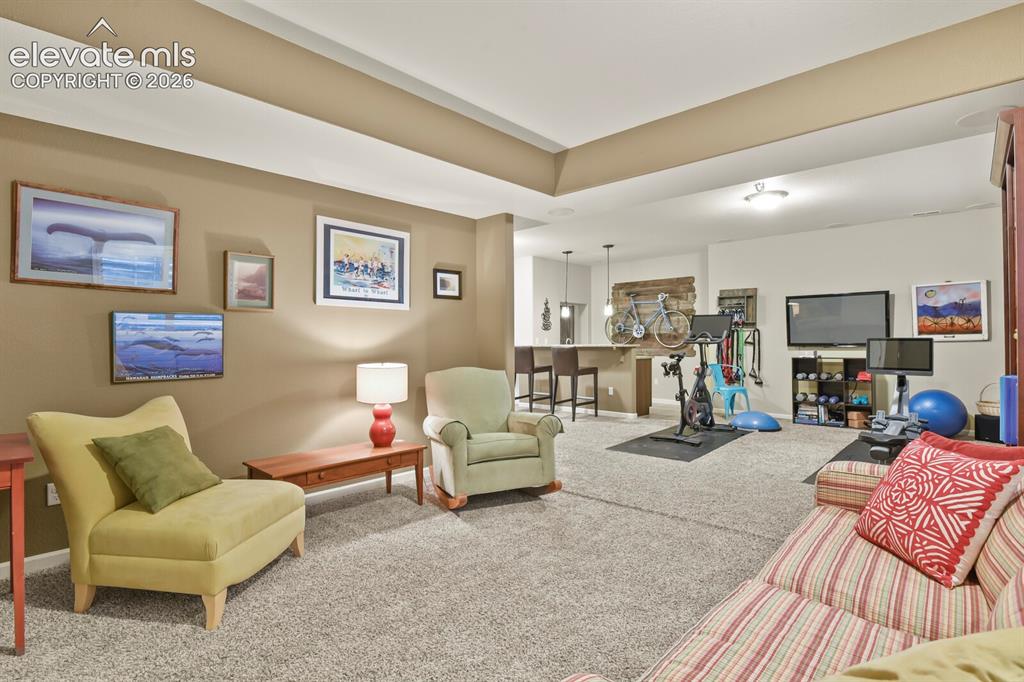 Image 33 of 47: Basement rec room includes space for a sitting area to cozy up.