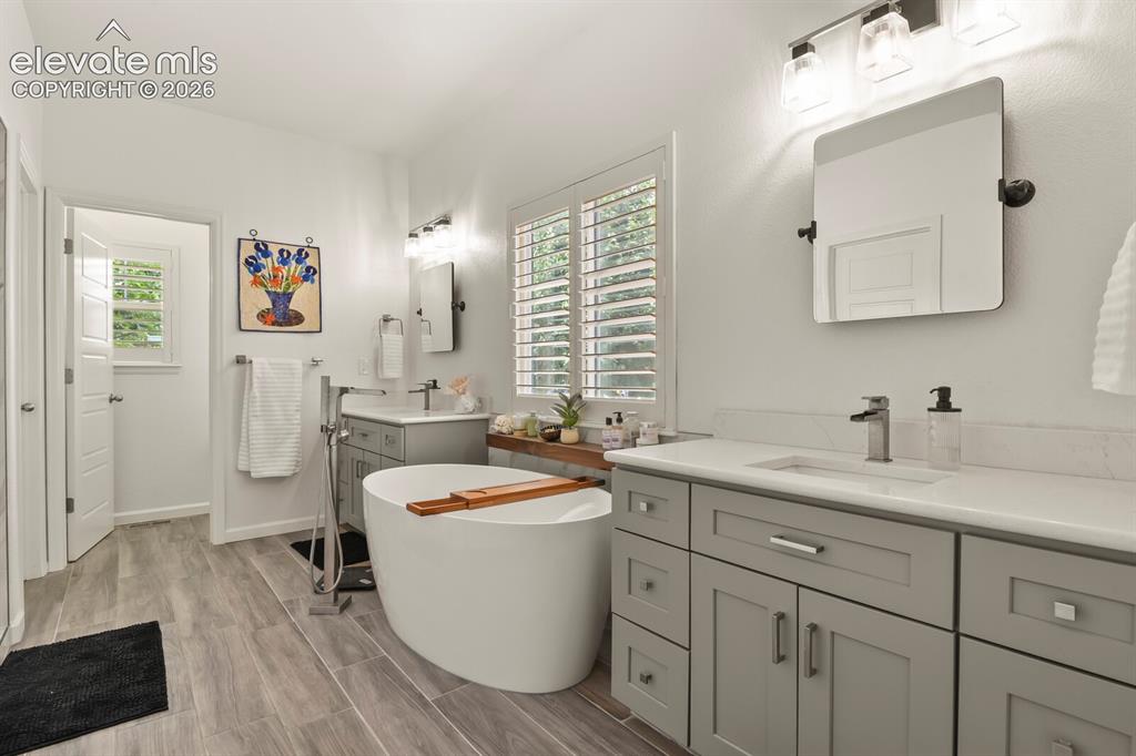 Image 4 of 47: Newly renovated primary bath with spa-like feel. Beautiful soaking tub, dou