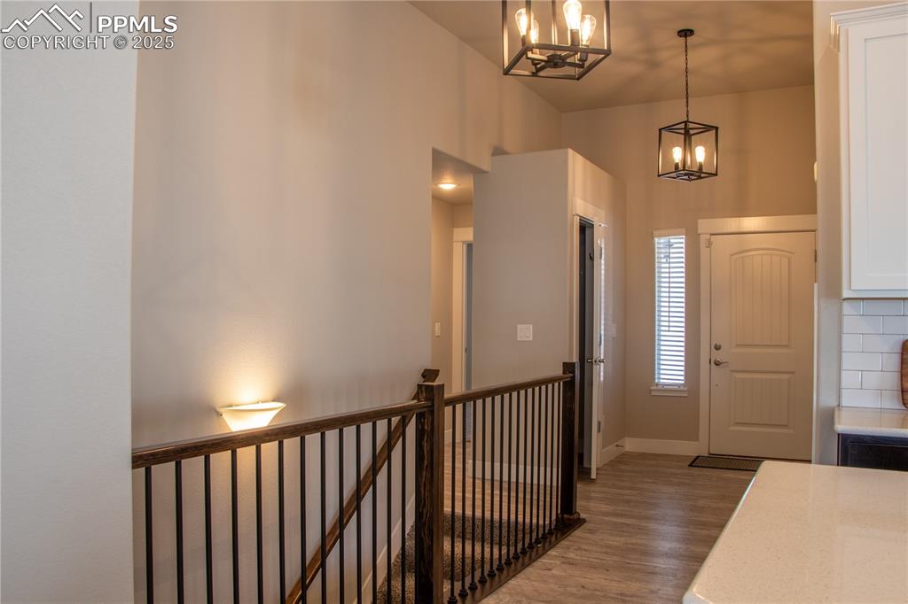 Image 20 of 30: Foyer entrance featuring wood finished floors and a chandelier