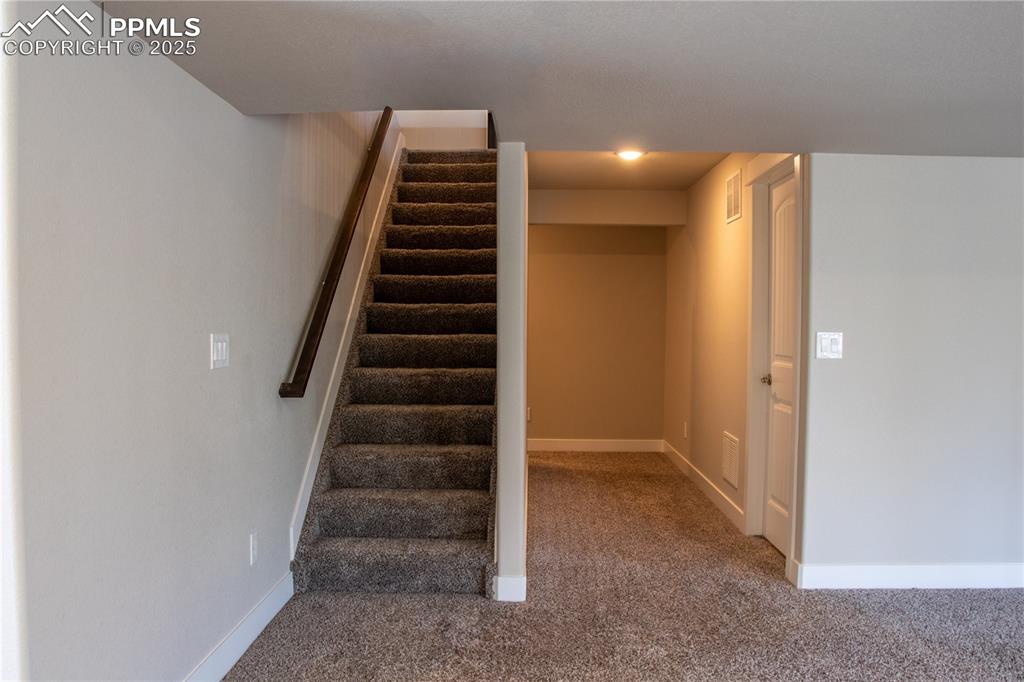Image 27 of 30: Stairway featuring carpet flooring and baseboards