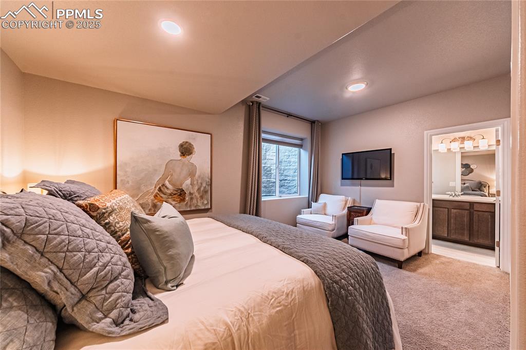Image 41 of 50: Carpeted bedroom with recessed lighting, connected bathroom, and vaulted ce