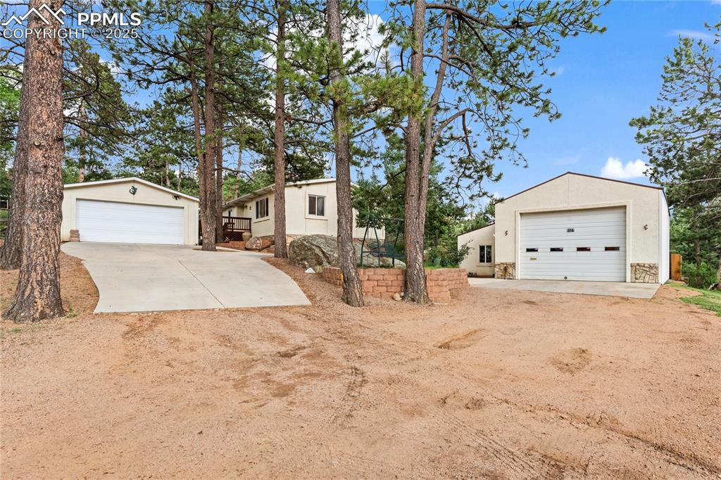 Caption: Stucco home, detached garage and mechanics shop