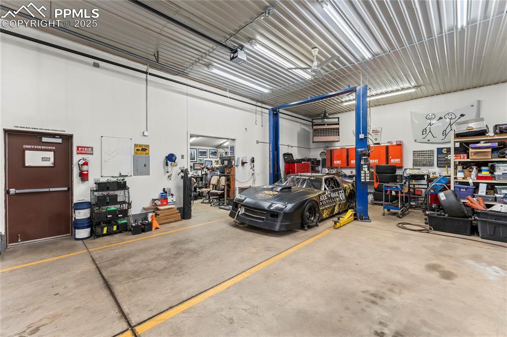 Image 11 of 42: Garage featuring a workshop area, electric panel, and a garage door opener