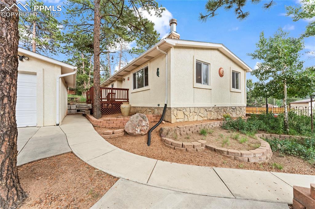 Image 15 of 42: View of side of home with a deck and stucco siding