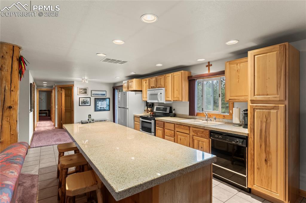 Image 21 of 42: Kitchen with a center island and breakfast bar 