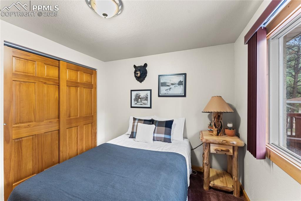 Image 27 of 42: Bedroom with dark carpet and baseboards