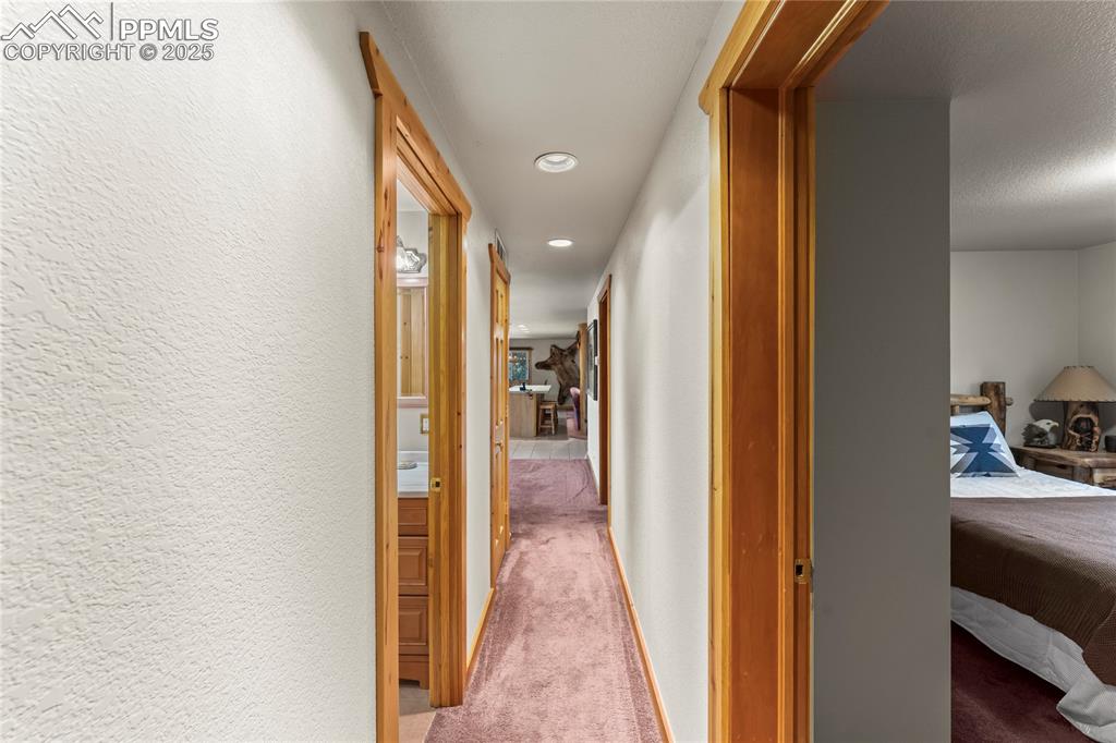 Image 32 of 42: Hall with carpet flooring, recessed lighting, and a textured wall