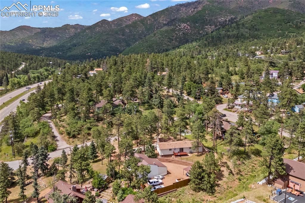 Image 41 of 42: Aerial view of property and surrounding area with mountains and a heavily w