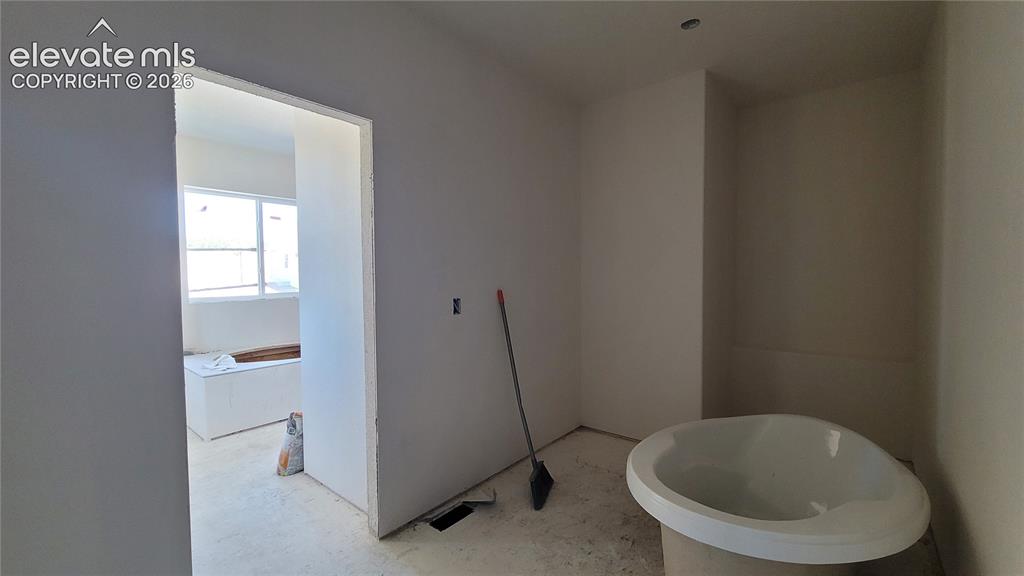 Image 19 of 30: Primary Walk-In Closet with Wood Shelving and Rods! Please, excuse our dust