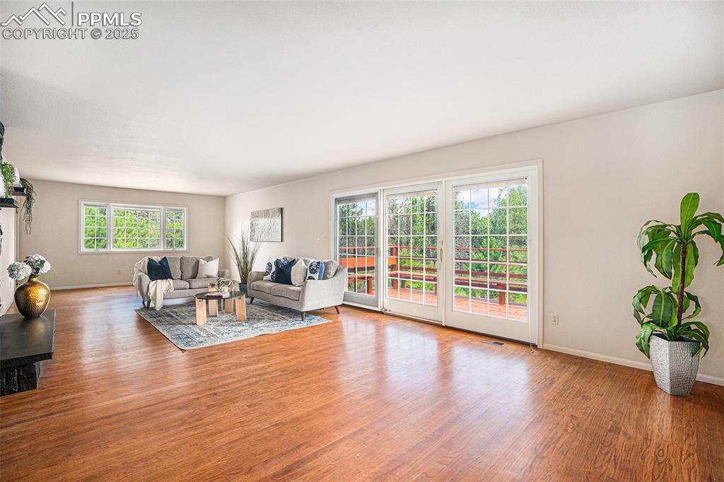 Image 4 of 34: Tons of natural light and real oak hardwood floors! Walkout to the deck.