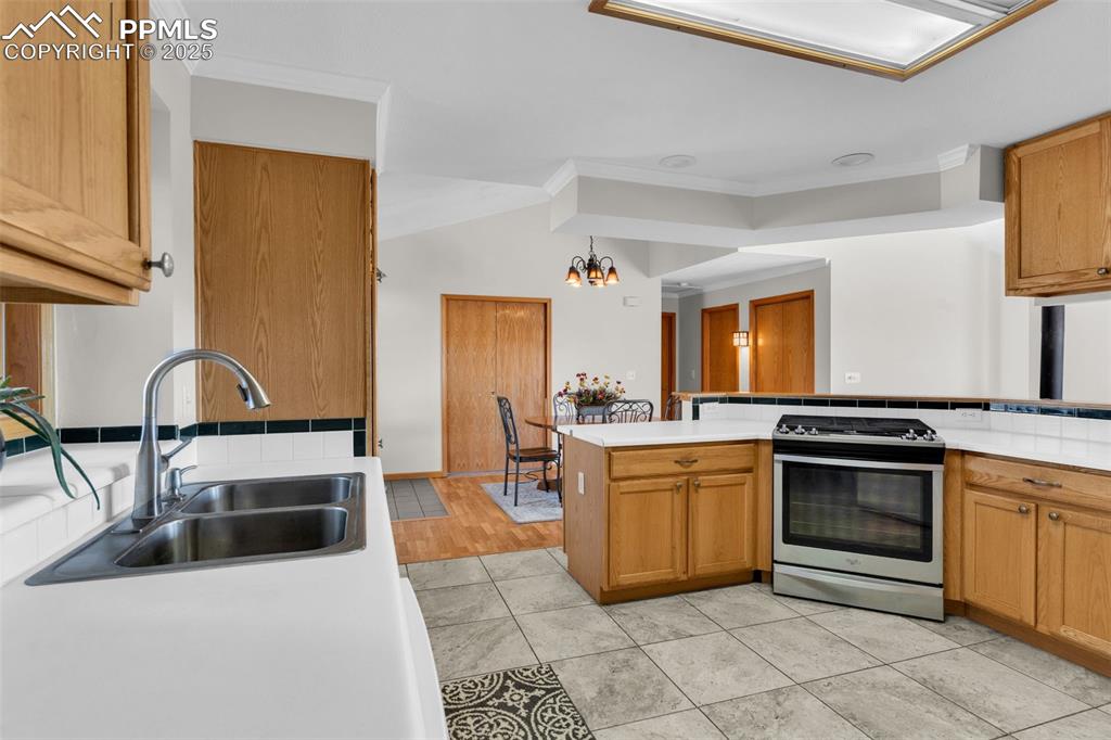 Image 17 of 50: Kitchen featuring crown molding, stainless steel range with gas cooktop, li