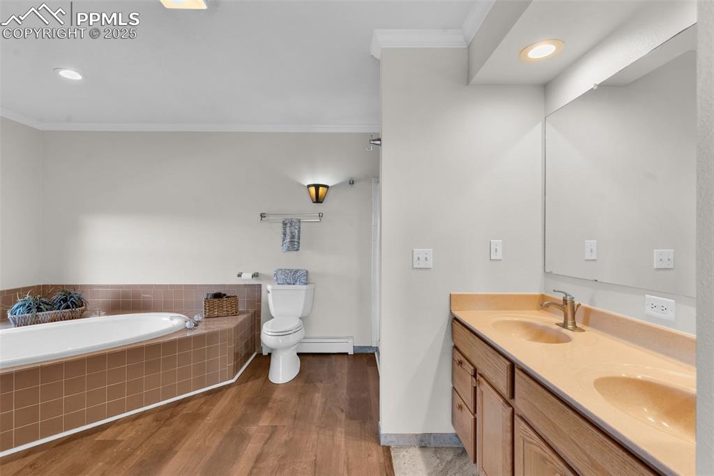 Image 21 of 50: Bathroom with recessed lighting, crown molding, dark wood-type flooring, do