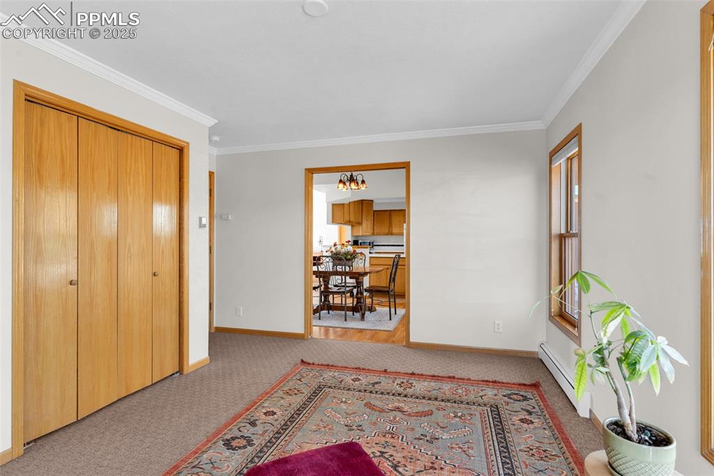 Image 27 of 50: Bedroom/Office with crown molding, carpet and baseboard heating.