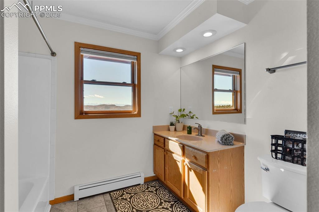 Image 28 of 50: Full bathroom featuring a baseboard radiator, crown molding, vanity, tub / 