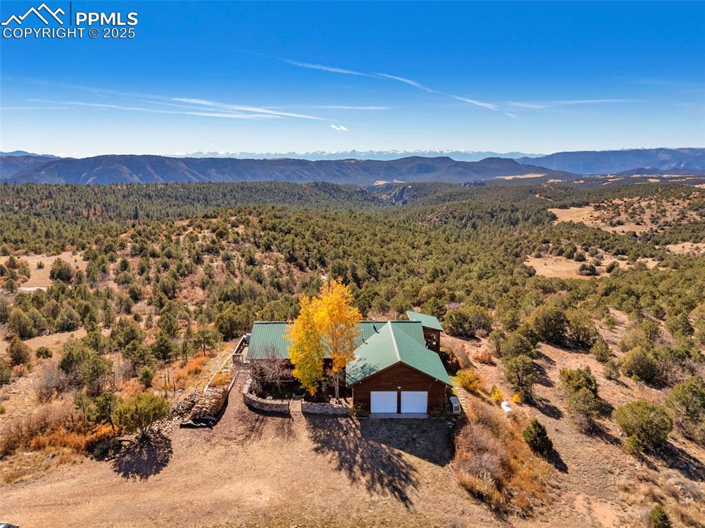 Image 45 of 50: Aerial view of property and surrounding area with a heavily wooded area and